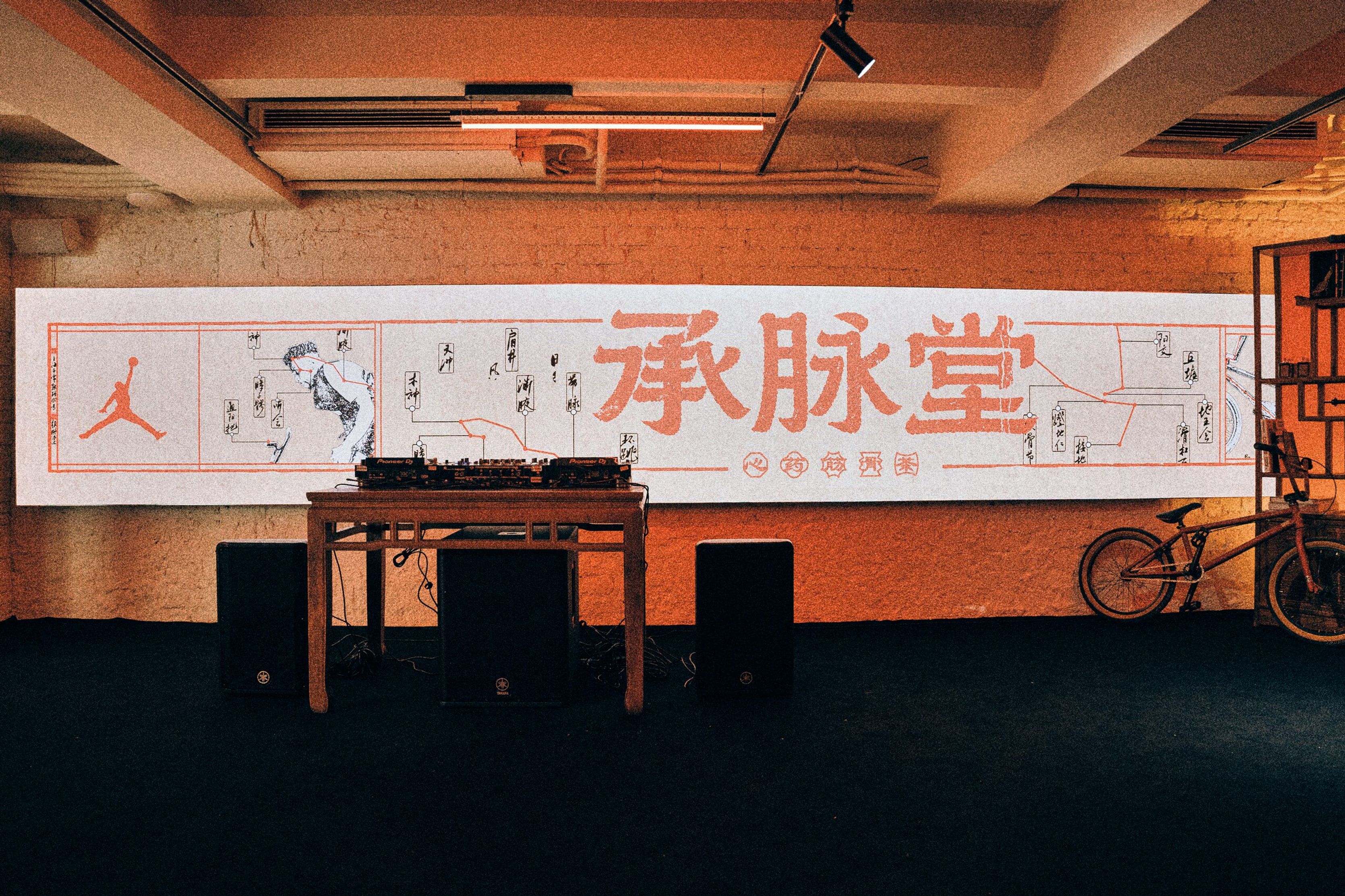 Long Cheng Mai Tang banner above a DJ booth and BMX bike