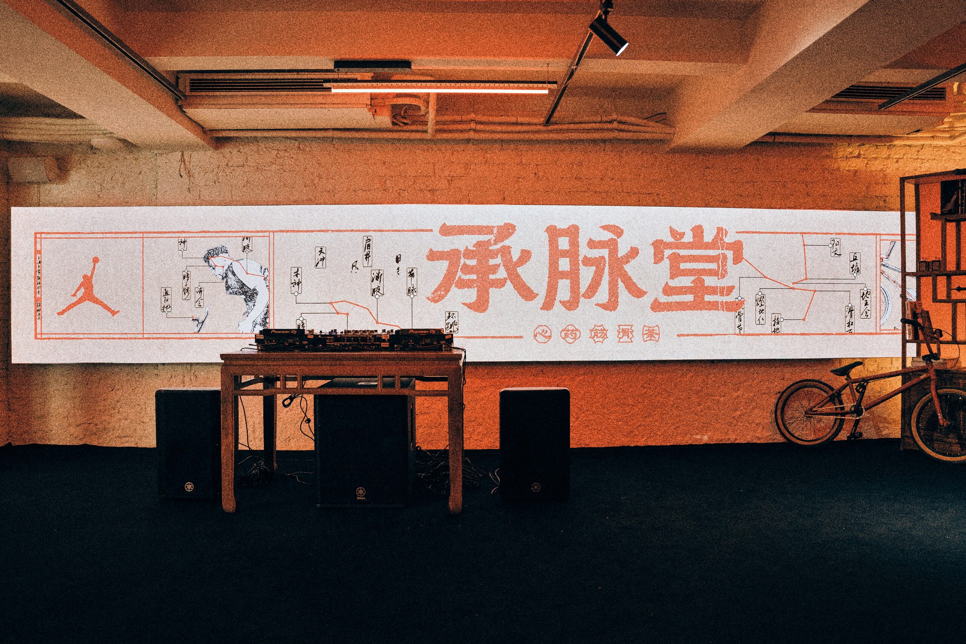 Long Cheng Mai Tang banner above a DJ booth and BMX bike