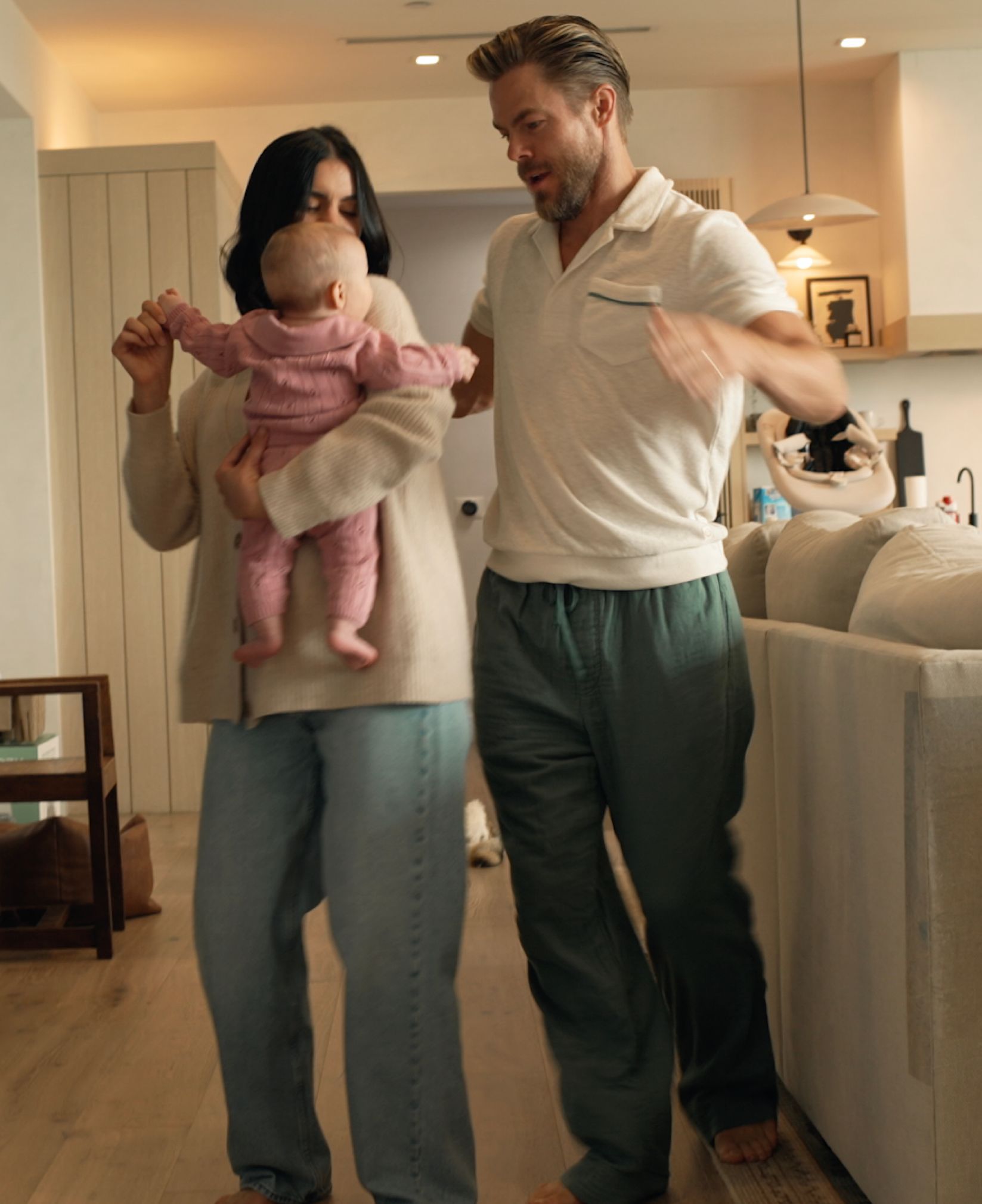 Derek Hough and Hayley Erbert dancing with their baby in the kitchen