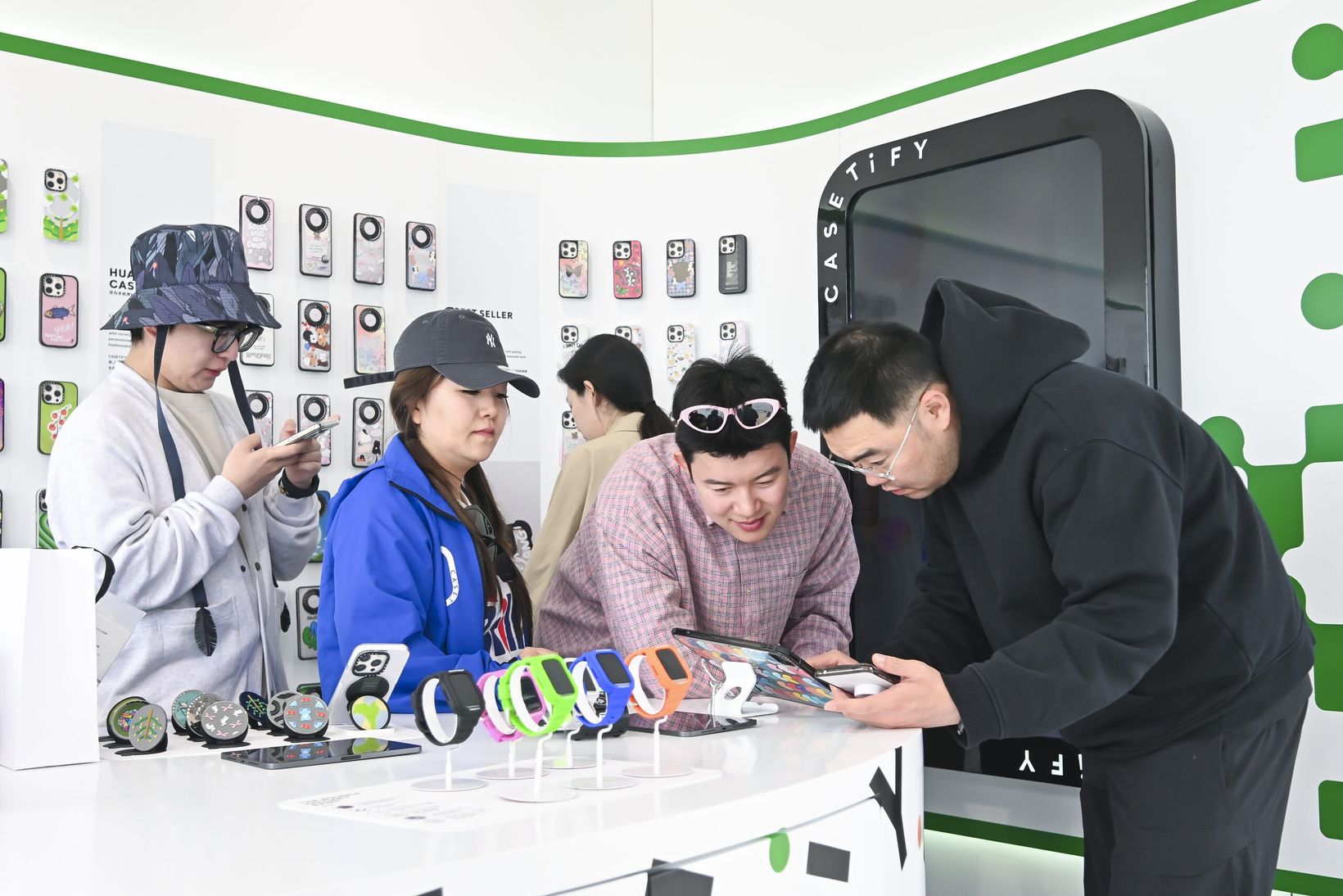 Visitors browsing phone cases at the counter inside the Aranya exhibition