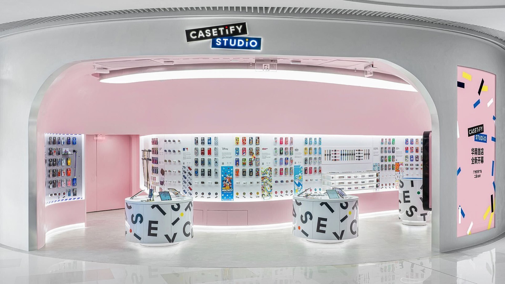 Pink CASETiFY Studio store with rounded walls and letter-covered stools