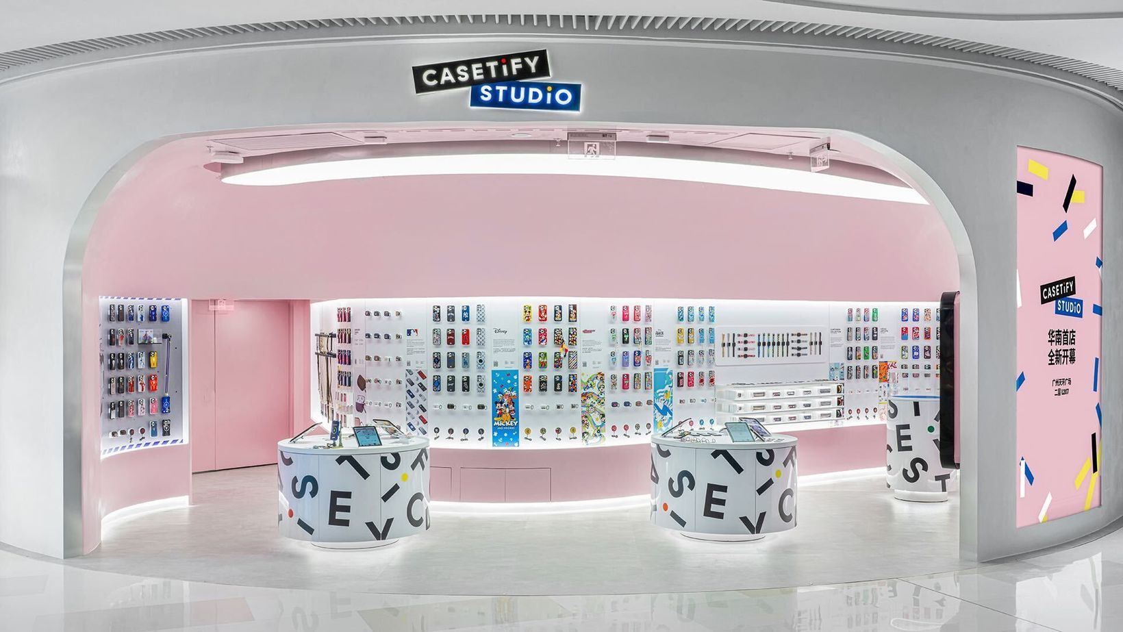Pink CASETiFY Studio store with rounded walls and letter-covered stools