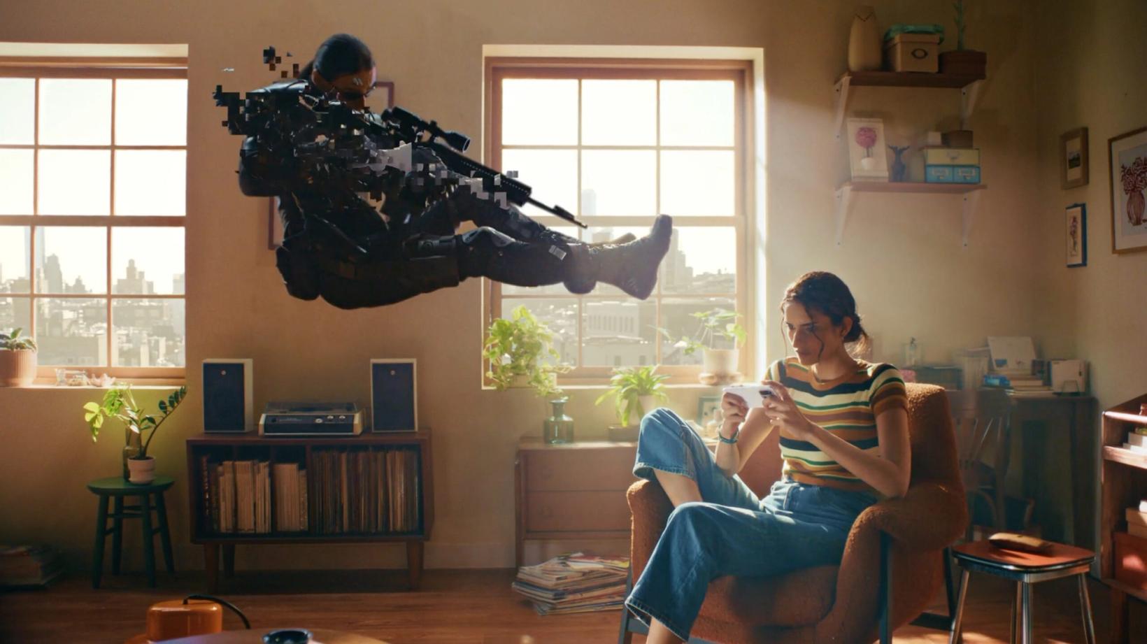 Armed soldier leaping through a living room as a woman plays on her phone