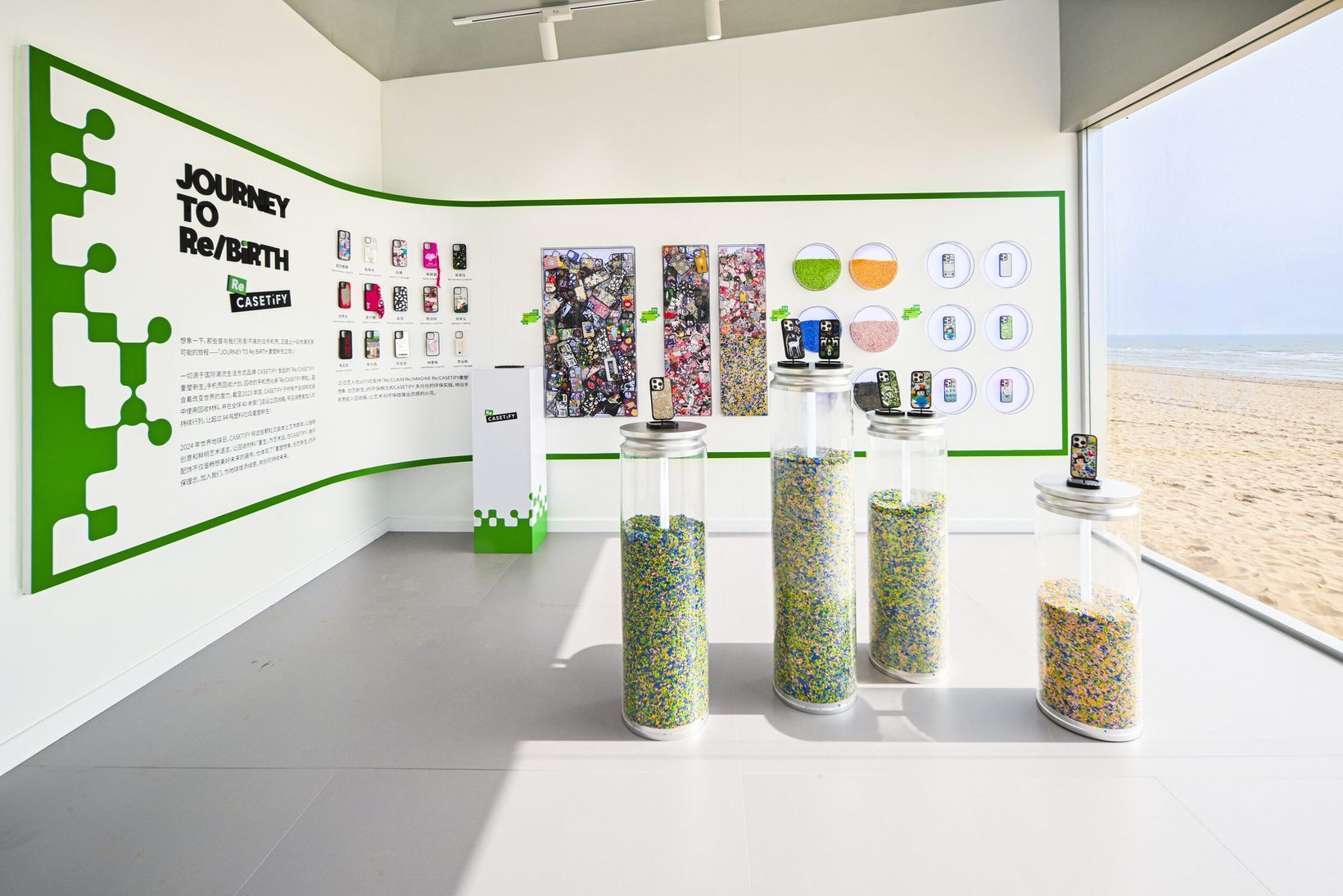 Journey to Rebirth exhibition interior with green graphics and jars of recycled pellets