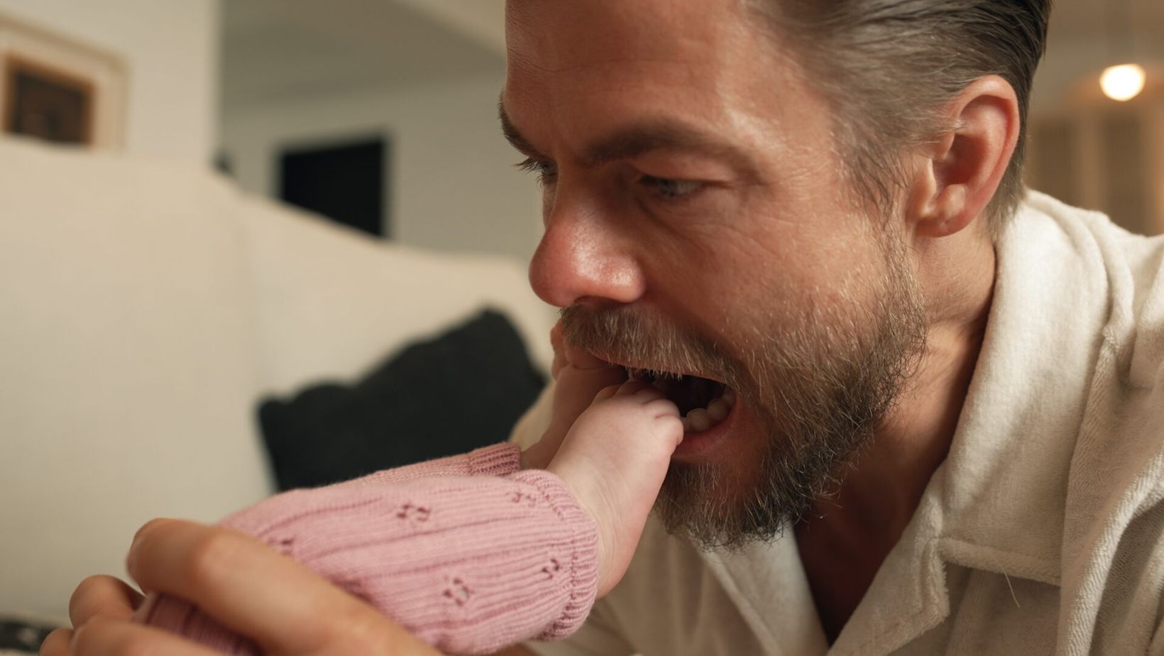 Derek Hough playfully nibbling his baby's foot