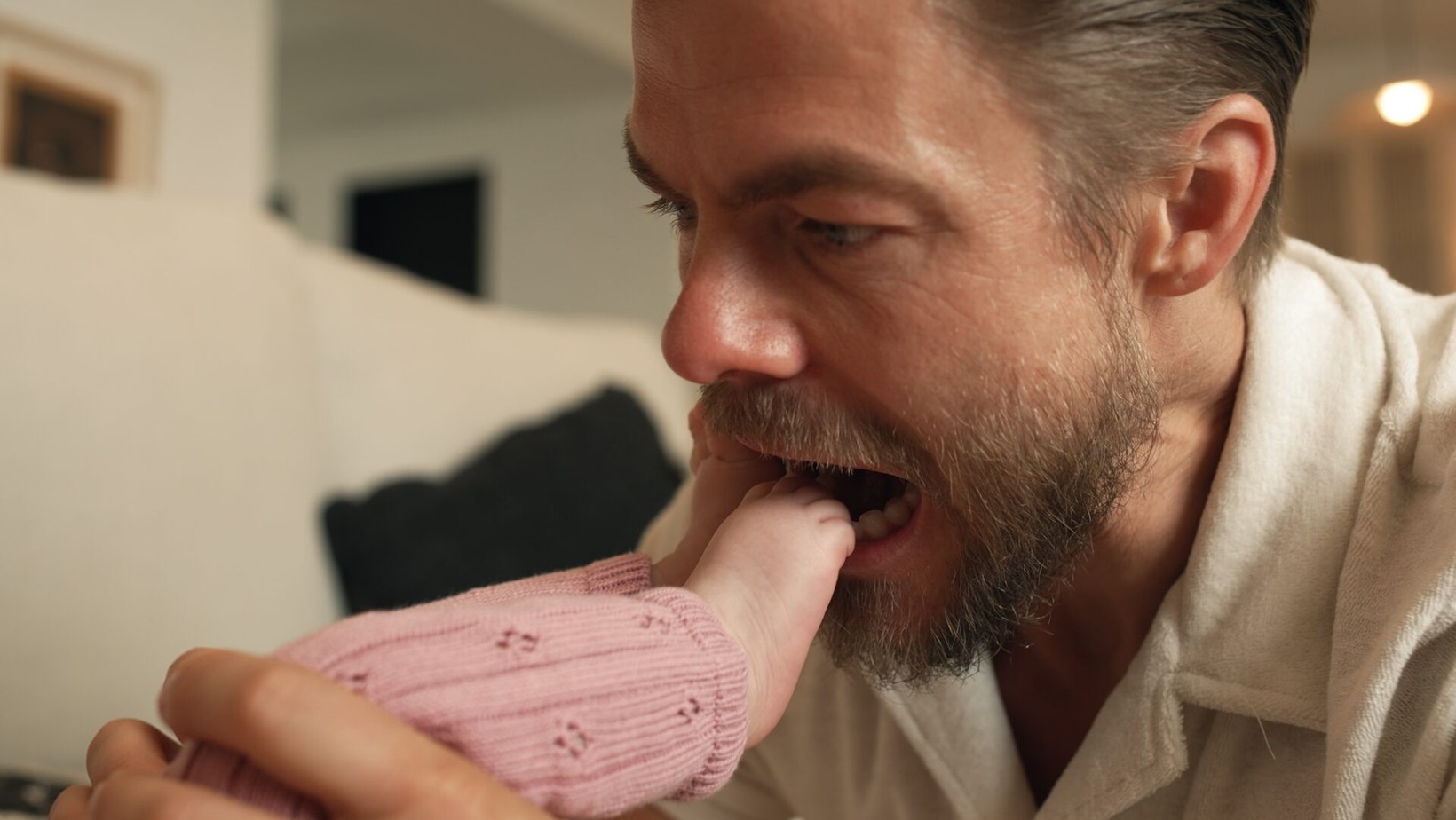 Derek Hough playfully nibbling his baby's foot