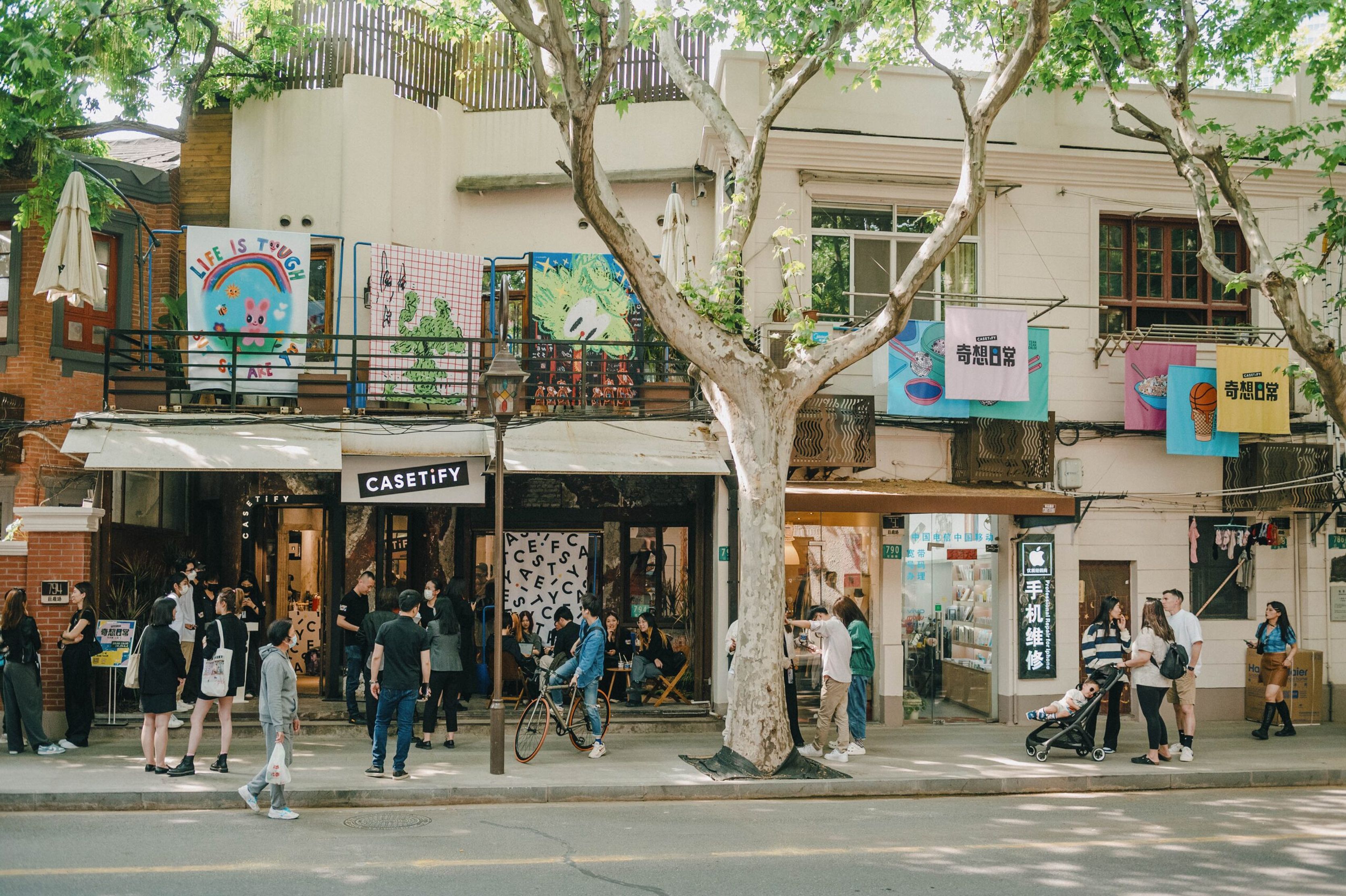 Crowds outside the CASETiFY exhibition building in Guanghua Li with artwork on the balconies