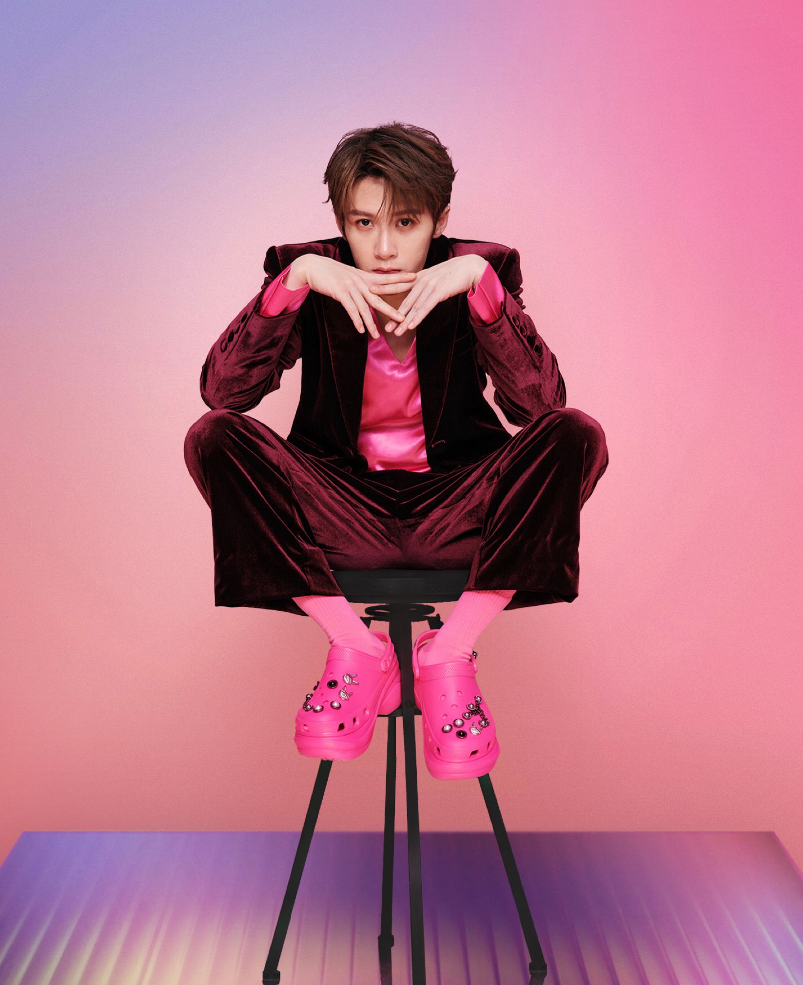 Tan Jianci seated at a desk in a pink room wearing pink Crocs