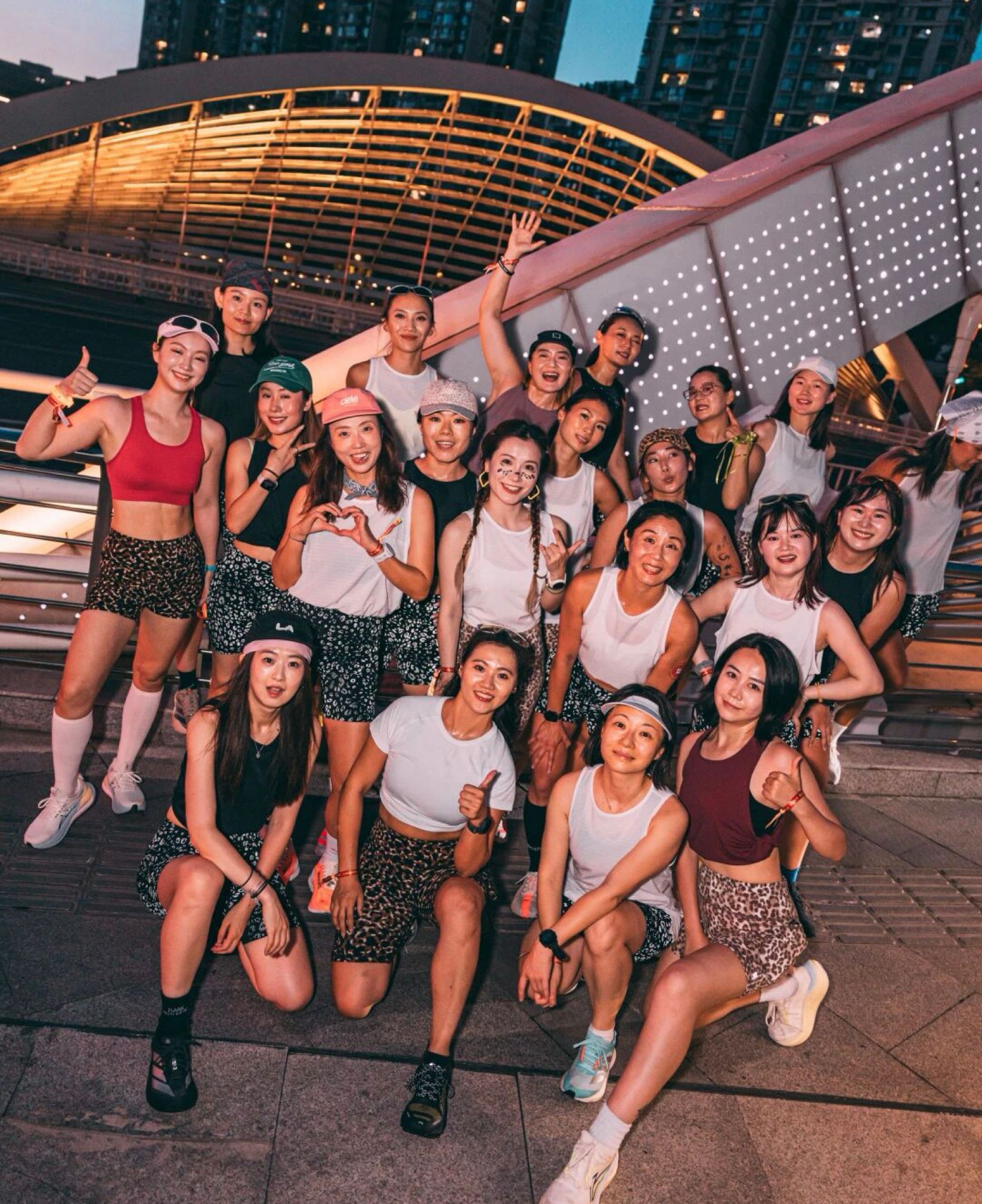 Group of women in activewear posing together outdoors at dusk