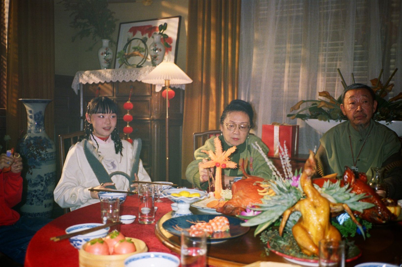Behind the scenes: cast in red and white seated at a New Year banquet table