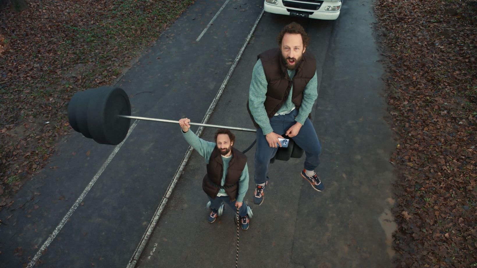 Man walking a dog on a lead attached to a giant weight