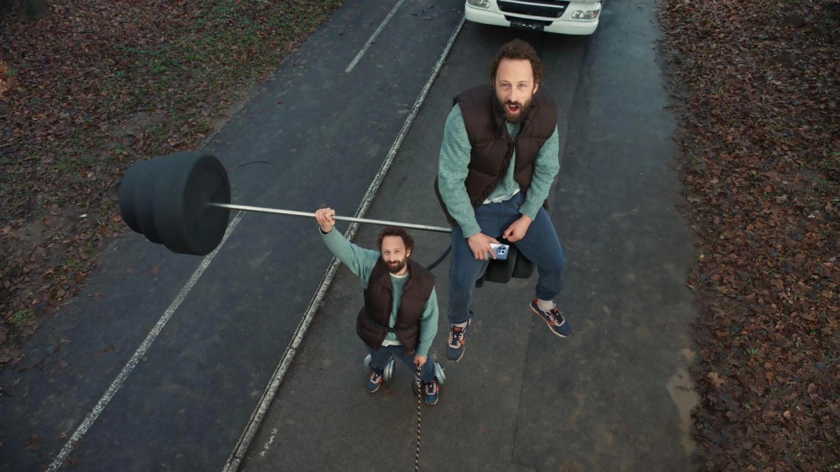 Man walking a dog on a lead attached to a giant weight