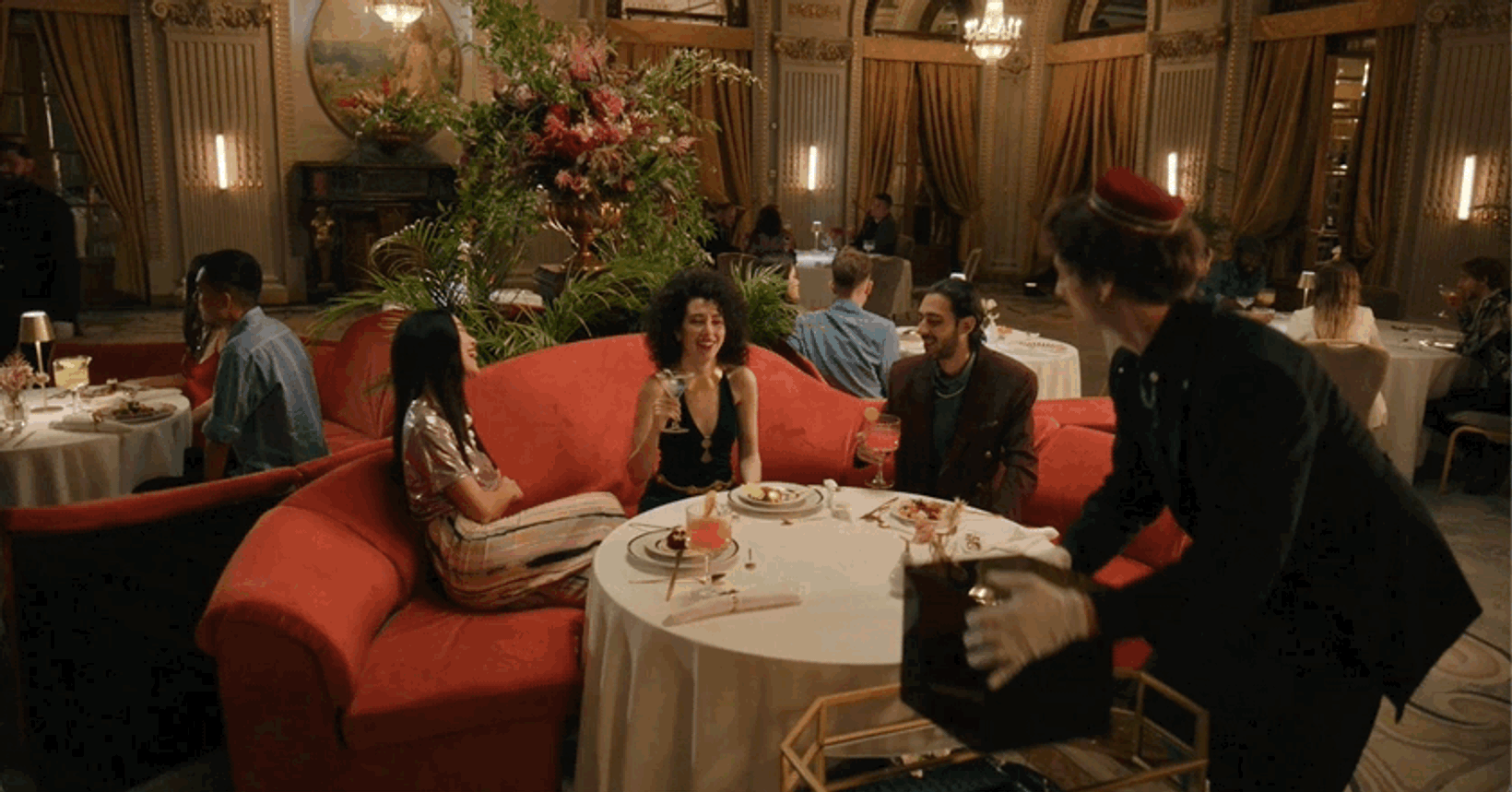 Waiter serving diners at a table in an ornate hotel restaurant