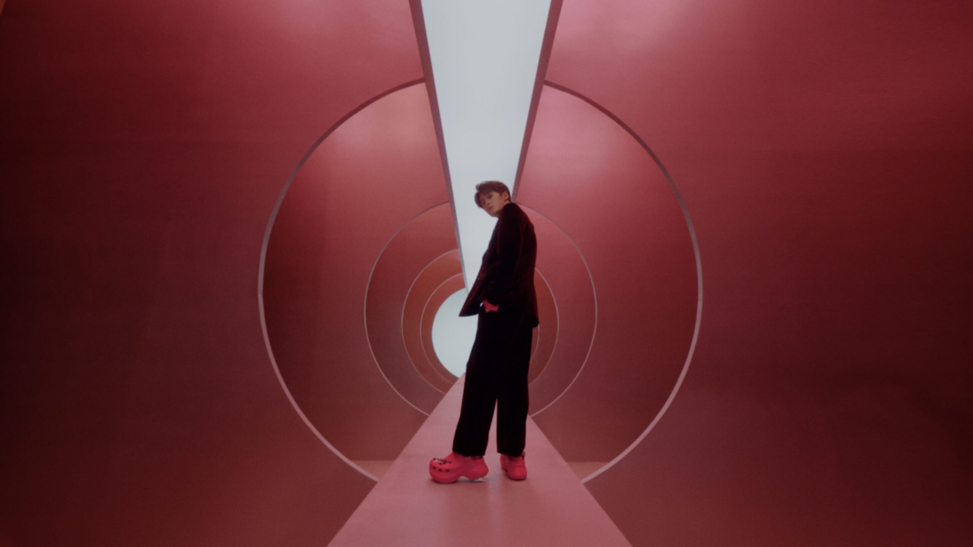 Film still of Tan Jianci standing in a red tunnel