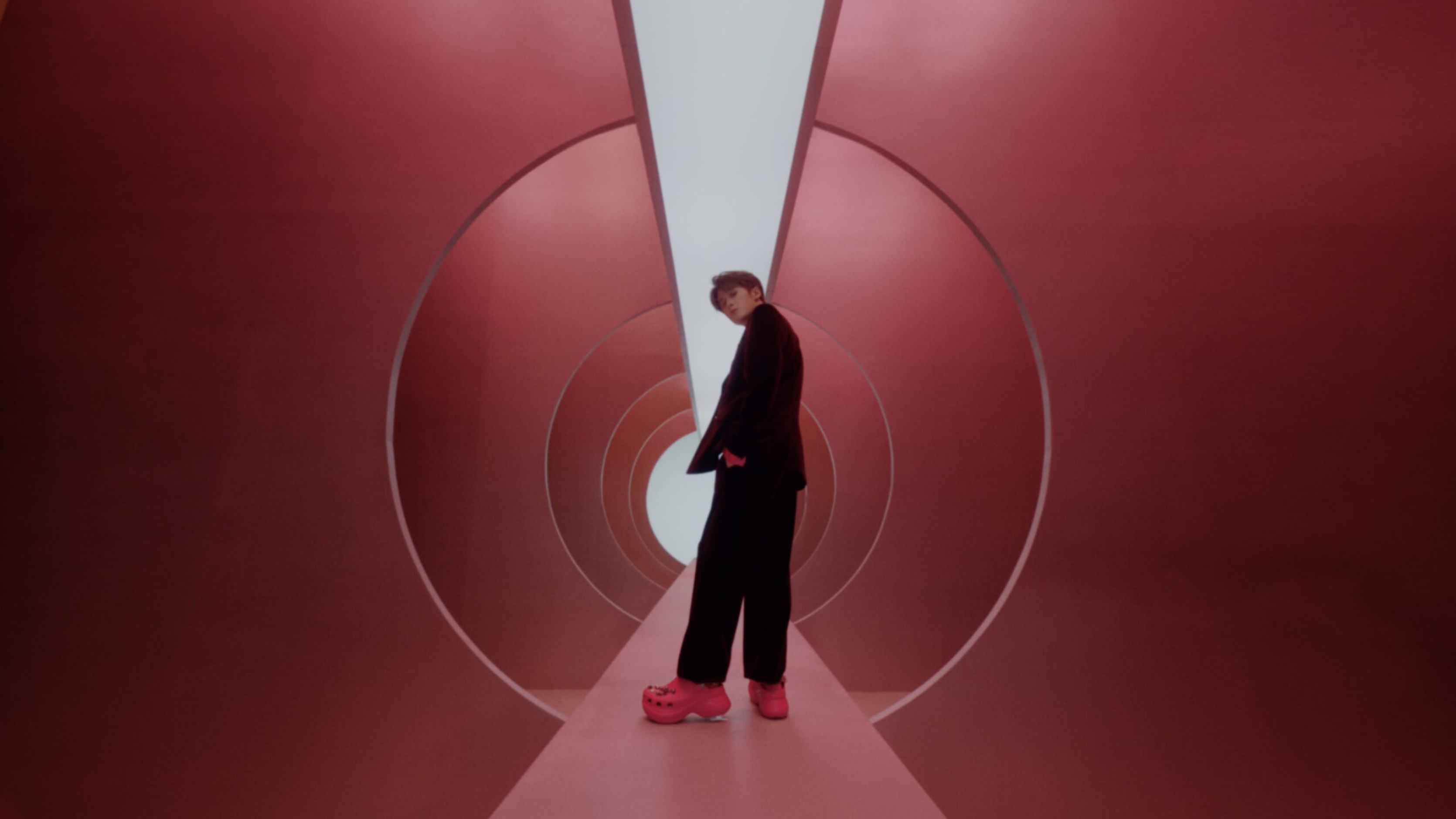 Film still of Tan Jianci standing in a red tunnel