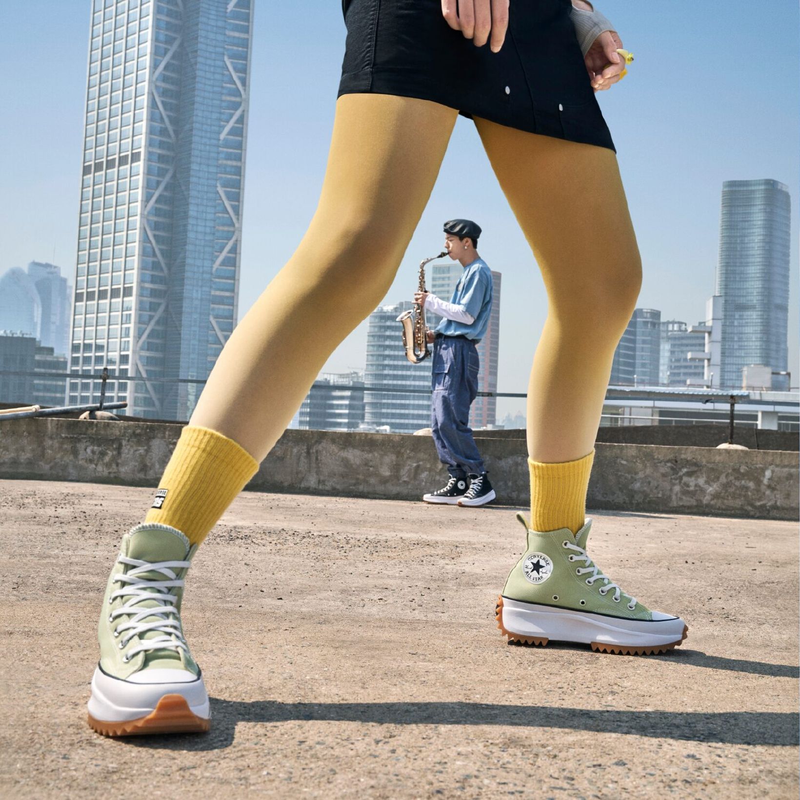 Close-up of green Converse platform sneakers and yellow socks on a rooftop