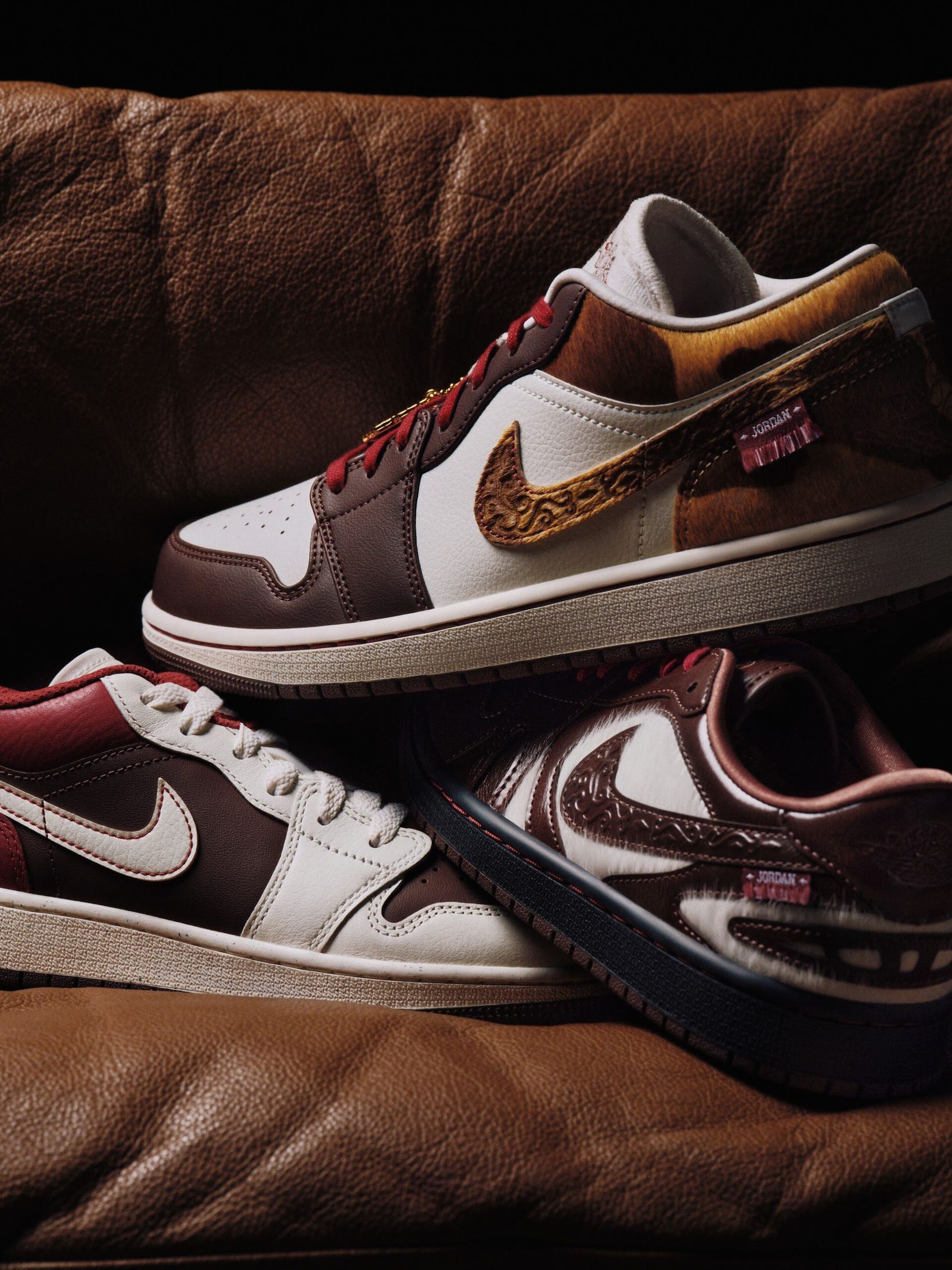 Two Air Jordan 1 Lows on a leather cushion
