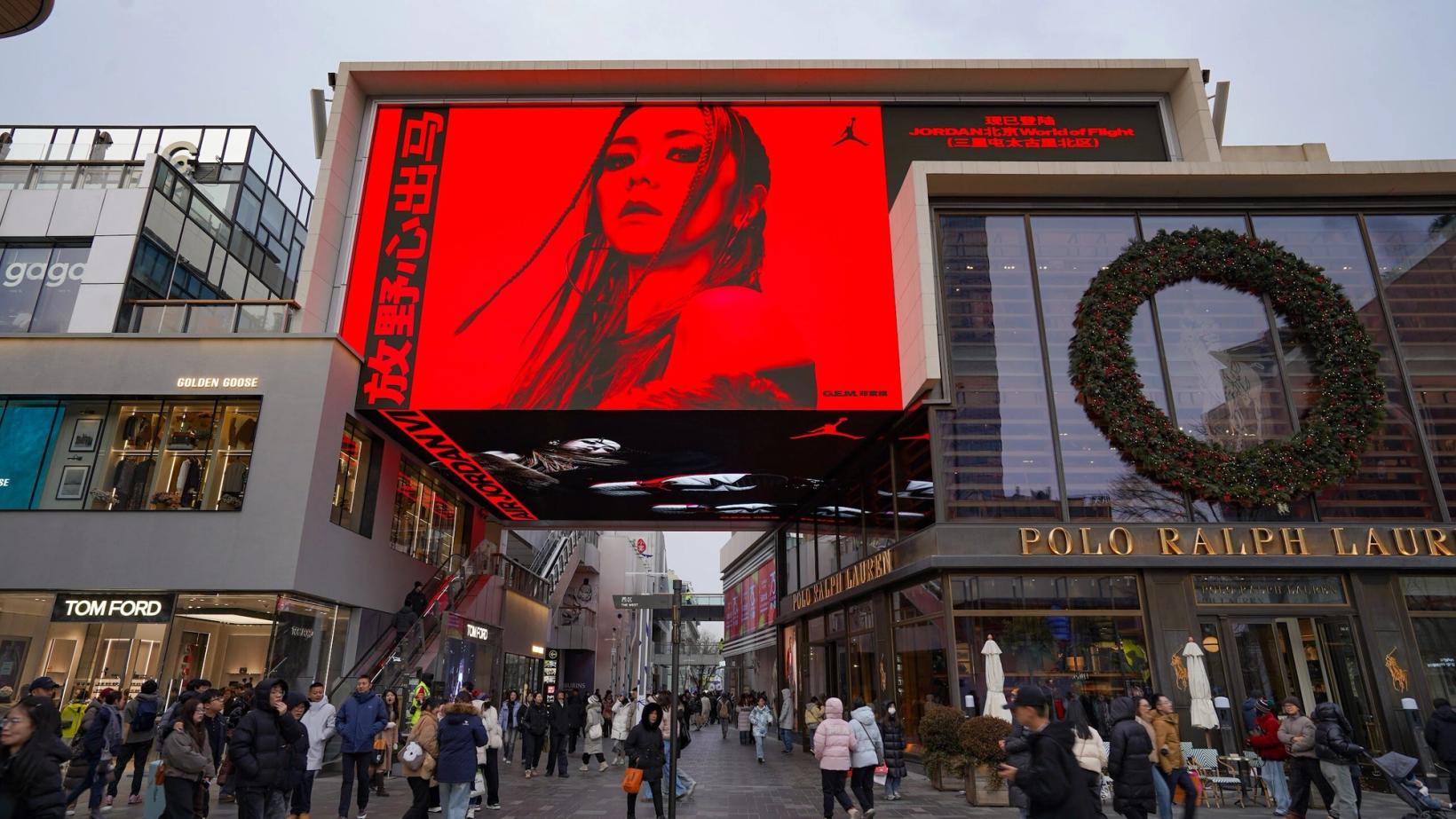 Large G.E.M. screen above a shopping street entrance