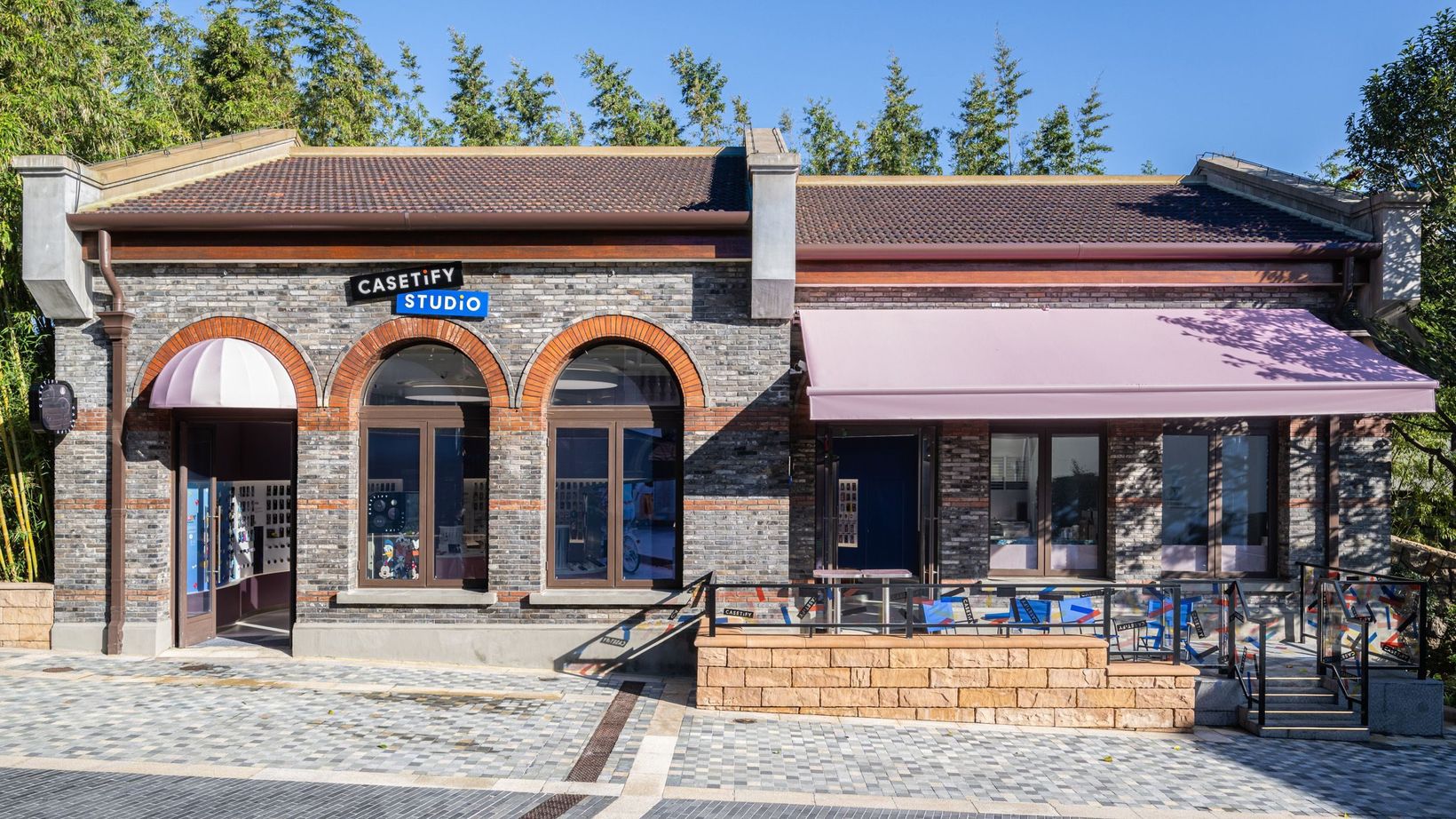 CASETiFY Studio storefront in a brick building with a pink awning
