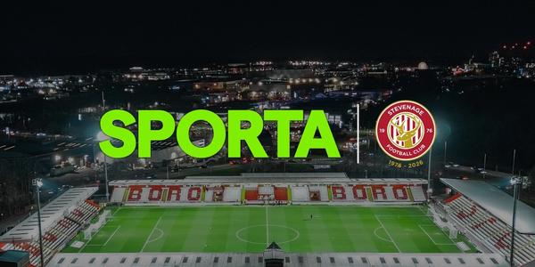 Logos of SPORTA and Stevenage FC against a backdrop of the SPORTA Arena at night.