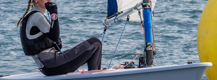 A solo female sailor on a small race boat.