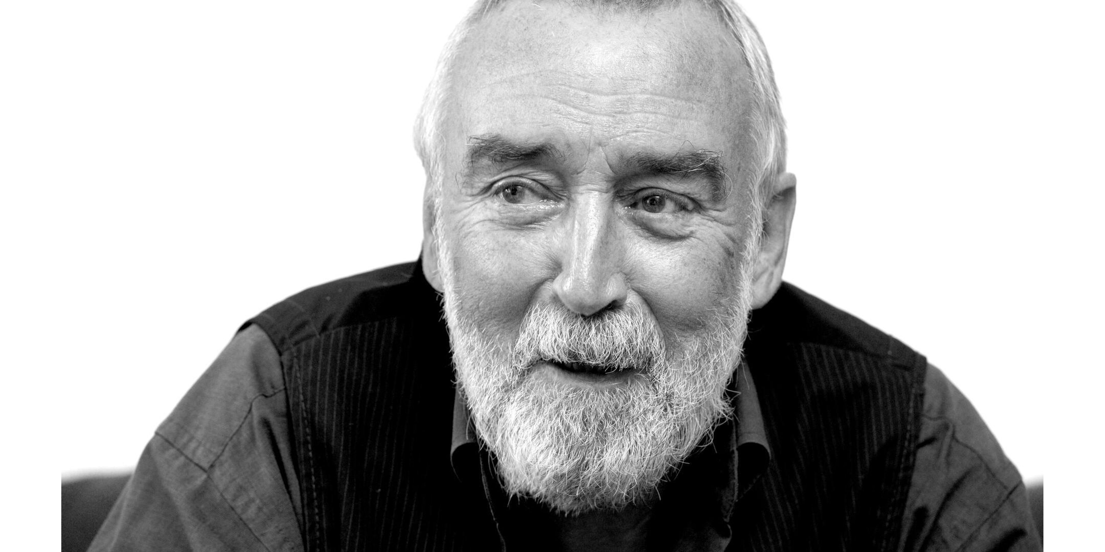 Black and white portrait of a smiling man with a white beard.