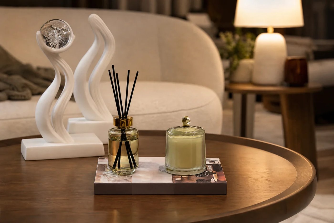 Mesa de centro con escultura, vela y luz cálida en una sala.