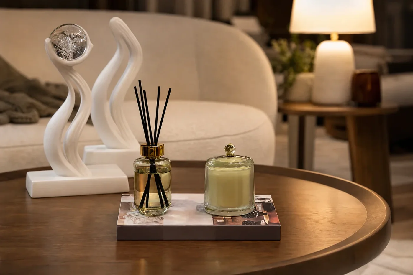 Mesa de centro con escultura, vela y luz cálida en una sala.