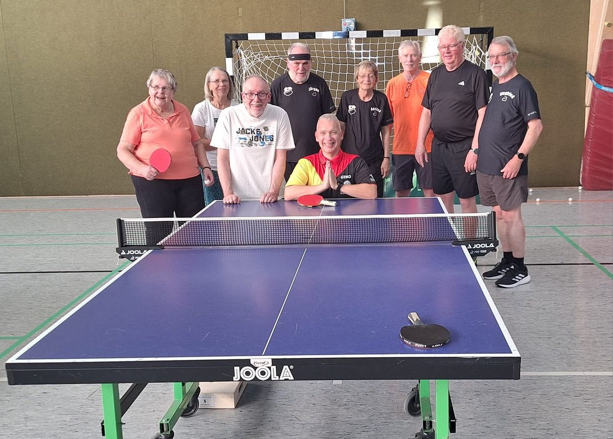 Die Parkinson-Gruppe des TTC Schwarz Weiß-Unna an der Platte, in der Bildmitte kniend Trainer Renee Bieder