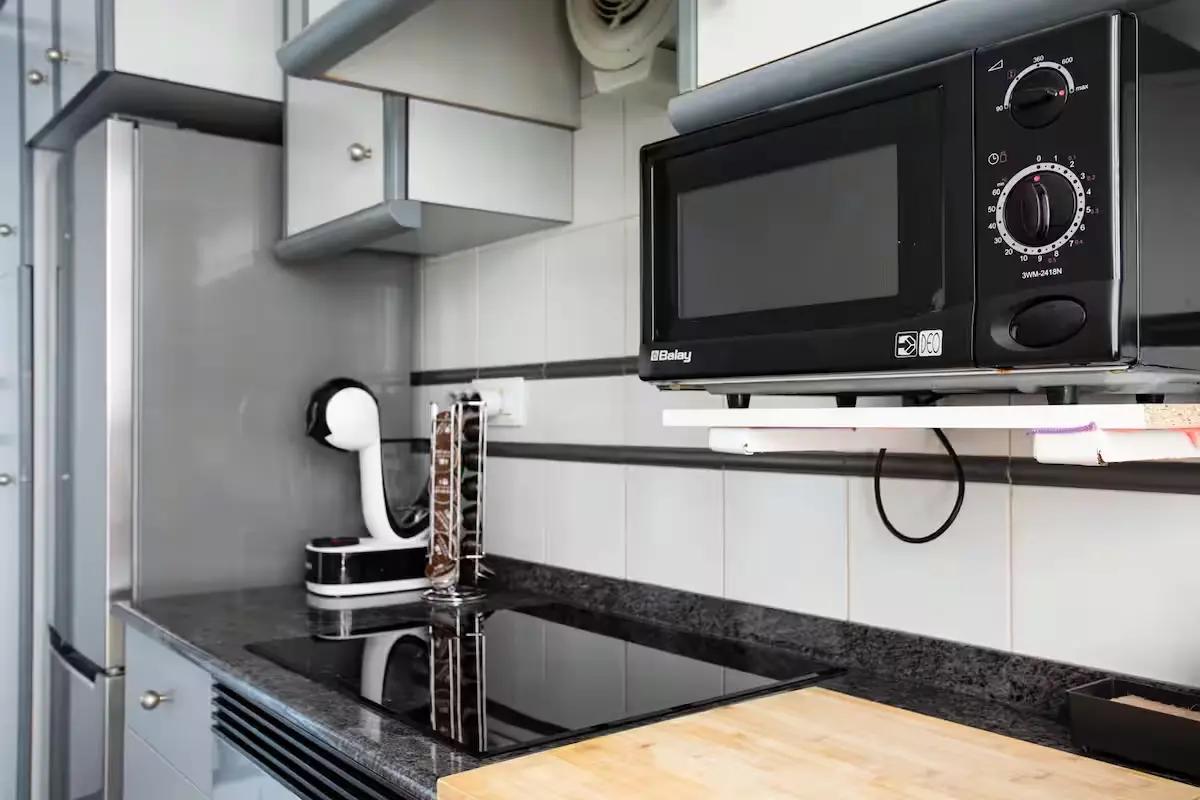 Cocina con cafetera Nescafé con cápsulas y microondas en el apartamento de Playa de Miramar