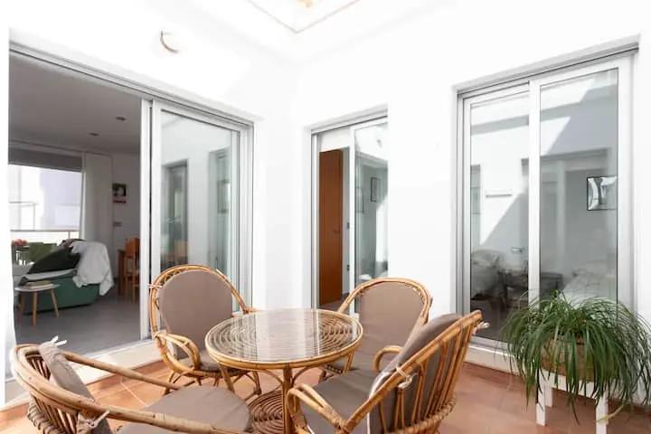 Mesa de mimbre con cuatro sillas en el patio interno de la casa de Miramar