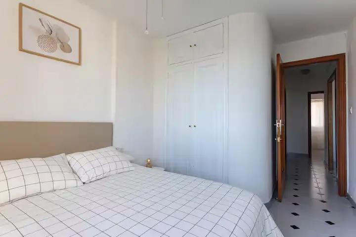 Dormitorio principal con cama doble y armario en el apartamento de la Playa de Miramar