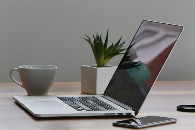 Escritorio ordenado con portátil, planta y taza de café para el mantenimiento de una web