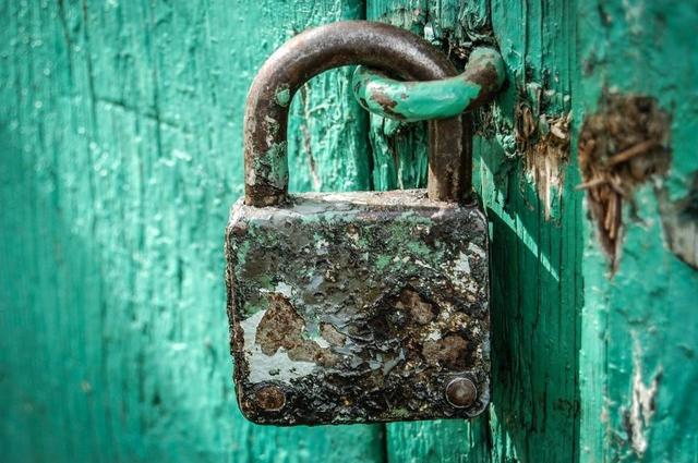Candado cerrando una puerta verde, como el certificado SSL que protege una web