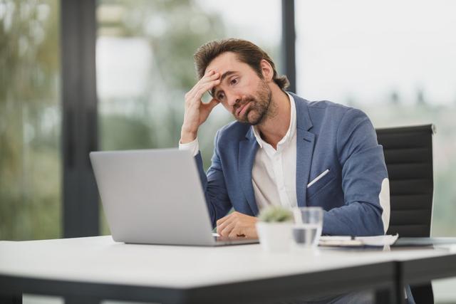 Empresario preocupado frente al portátil al notar que su web WordPress fue hackeada