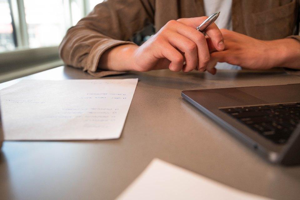 Mano con bolígrafo revisando una lista antes de actualizar un plugin