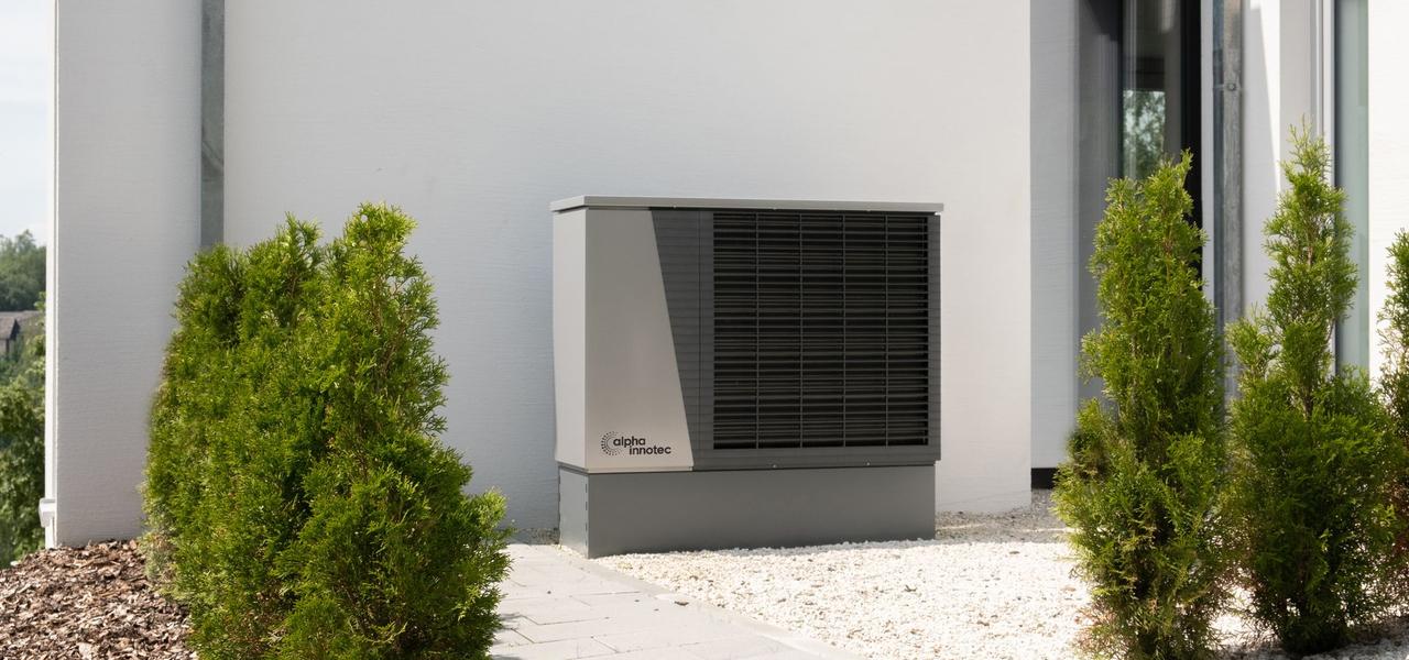 Warmtepomp buiten naast een moderne woning
