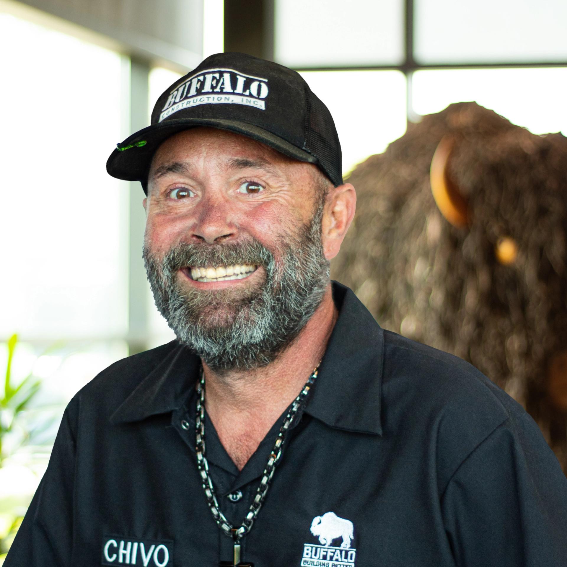 Anthony Abbott with a big smile as he stands in front of a statue of a buffalo.