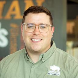 Jack Doherty wearing buffalo branded button down and standing in front of a company-branded wall.