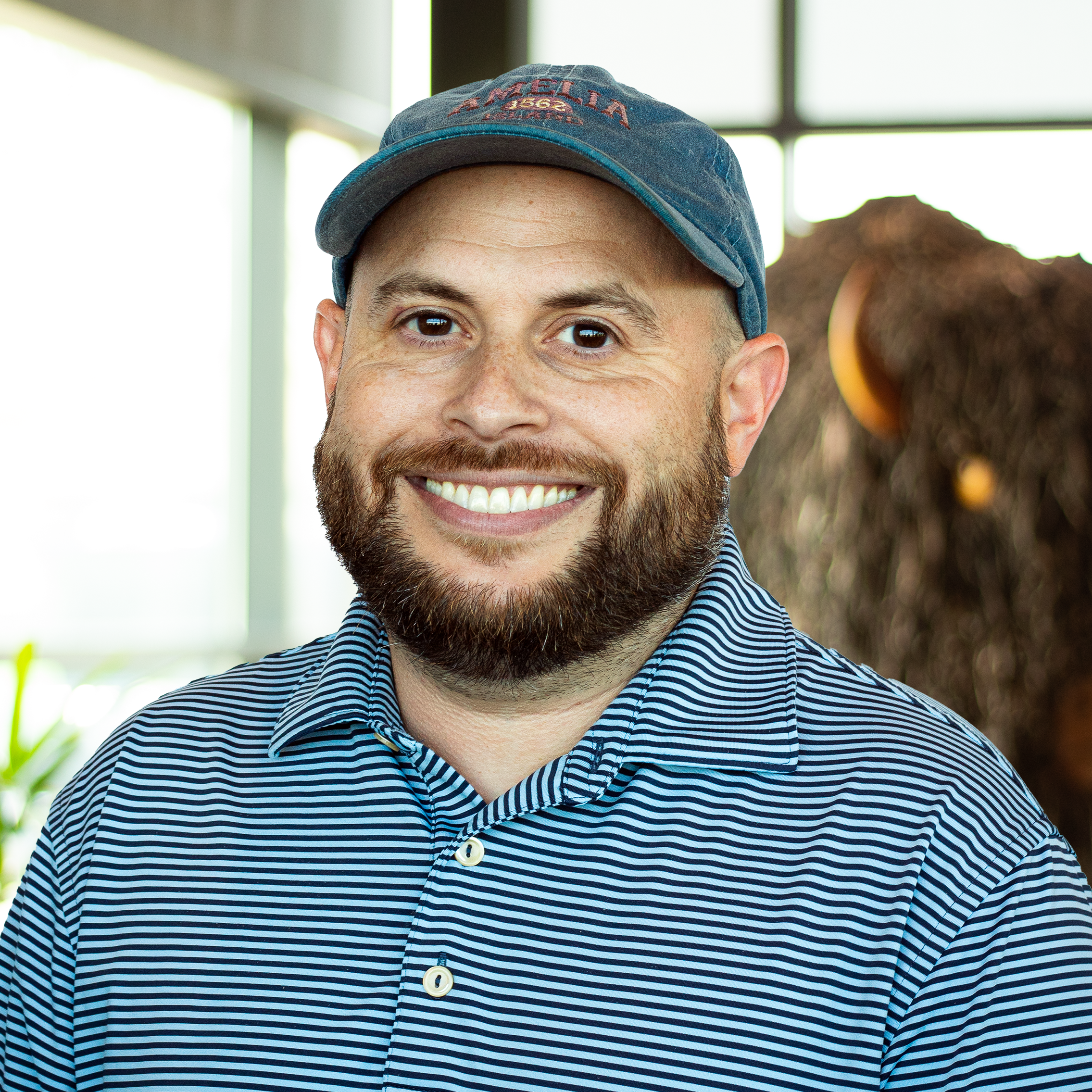 Max Kushner with a big smile and standing in front of a statue of a buffalo.