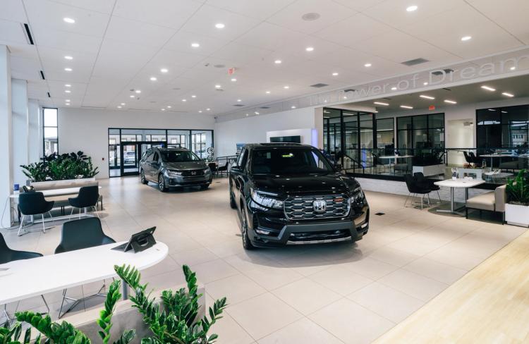 Completed Honda showroom featuring vehicle displays, modern customer seating, interior landscaping and glass-enclosed offices.