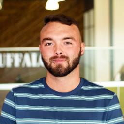 Caleb Marcum wearing a stripped shit and standing tall in buffalo's office space.