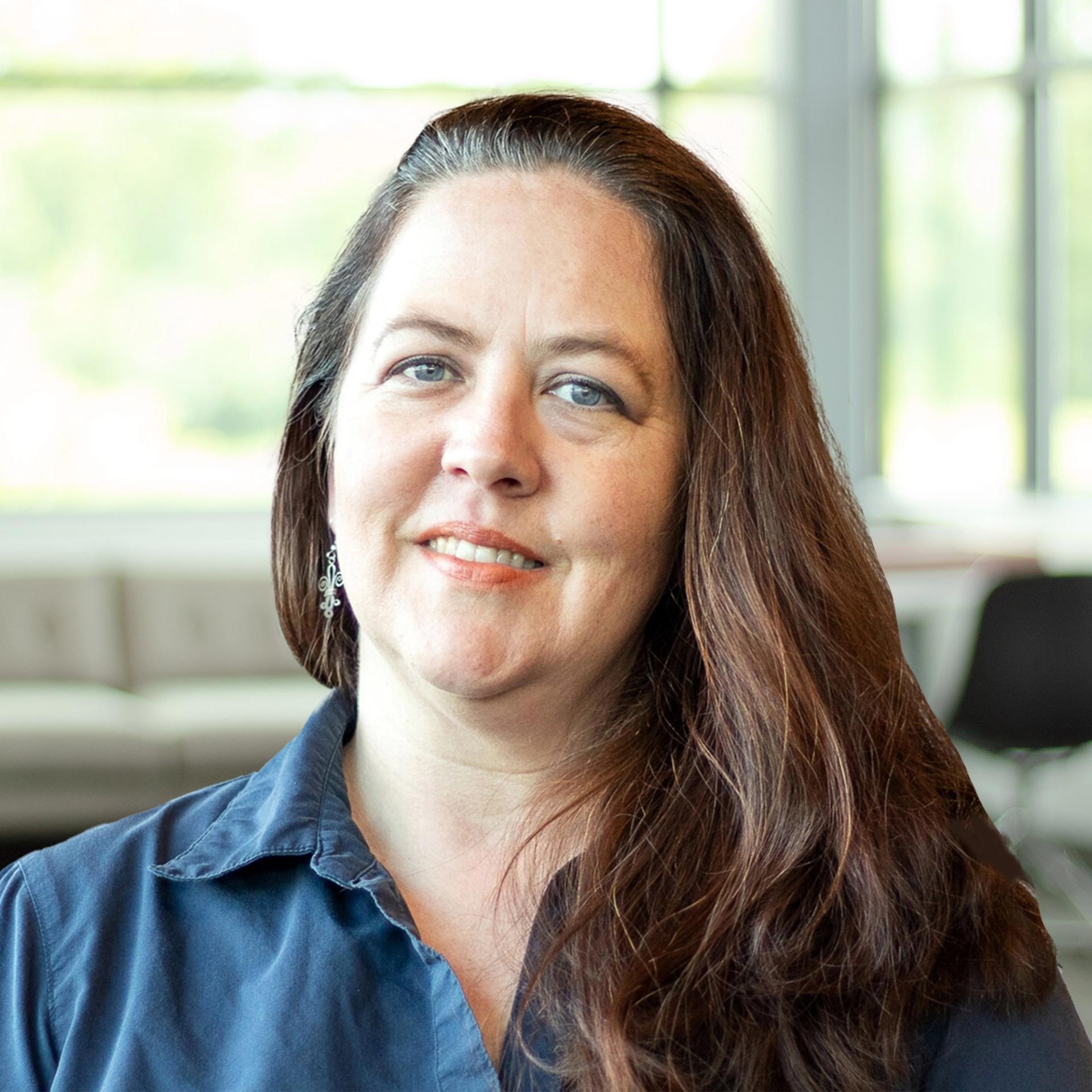 Shiloh Trahan smiling in a bright, modern office.