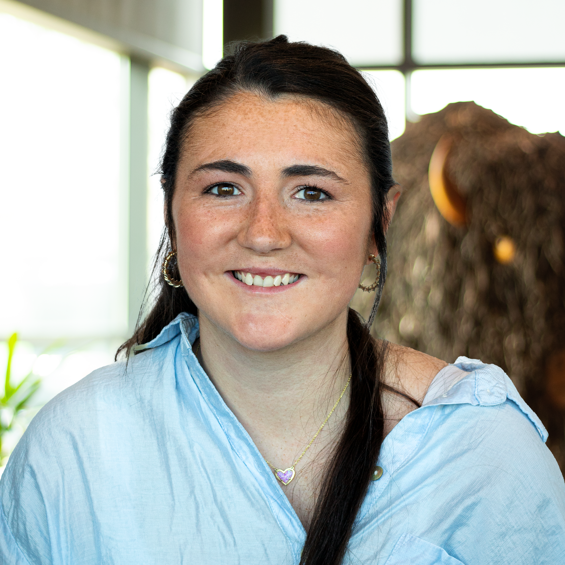 Stevye Gonzales smiling as she stands in front of a statue of a buffalo.