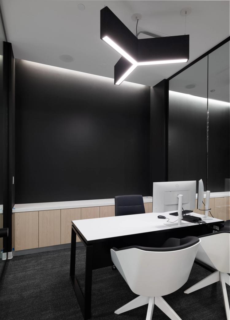 Private office with modern lighting and desk.