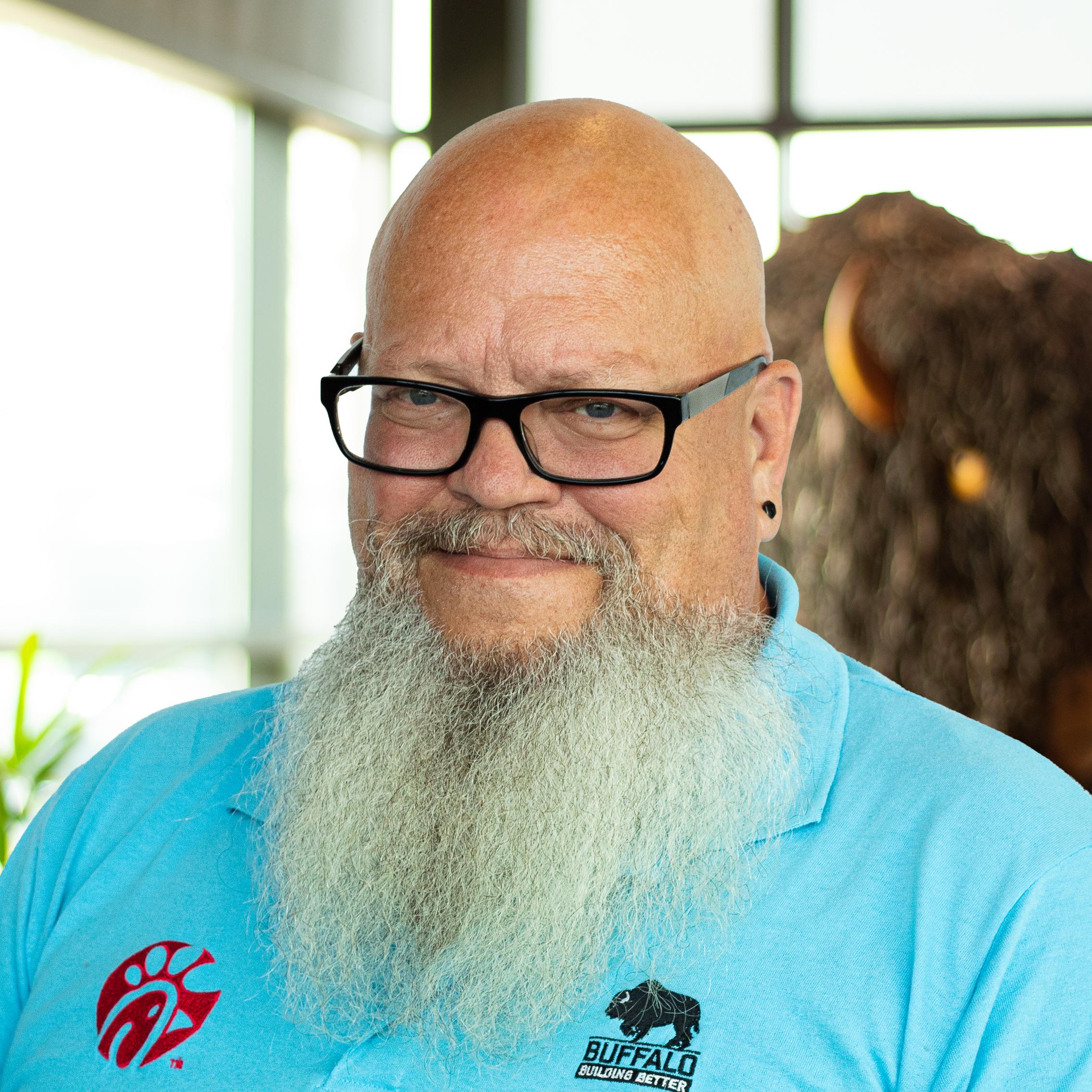 Jay Wilson giving a smile while standing in front of the Roman A. Buffalo sculpture.