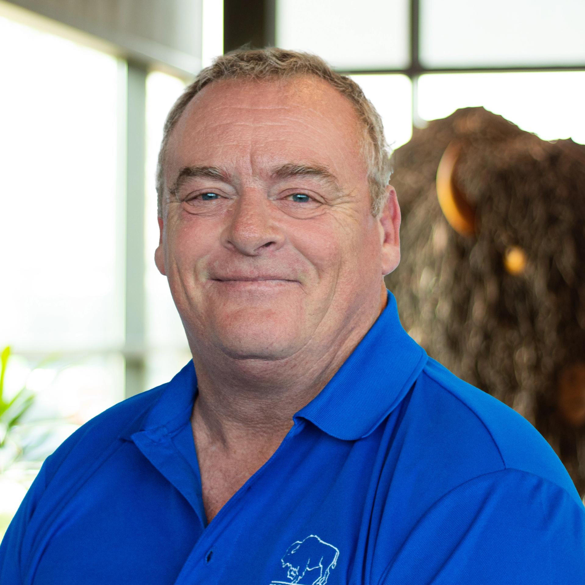 Adrian Jackson, smiling as he stands in front of a statue of a buffalo.