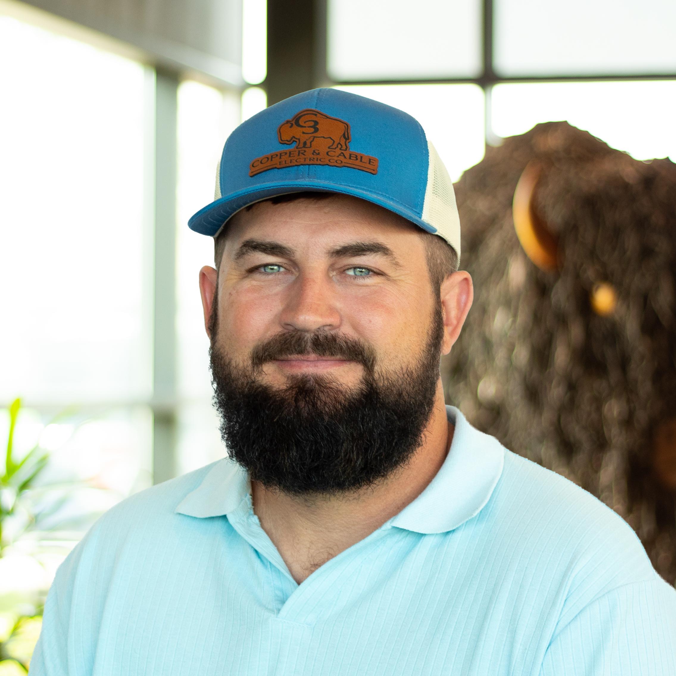 Chris Clark smiling as he stands in front of a statue of a buffalo.