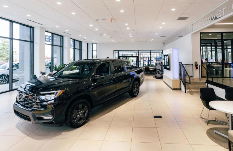Completed Honda showroom with a black pickup truck, floor-to-ceiling windows, customer seating and glass-enclosed offices.