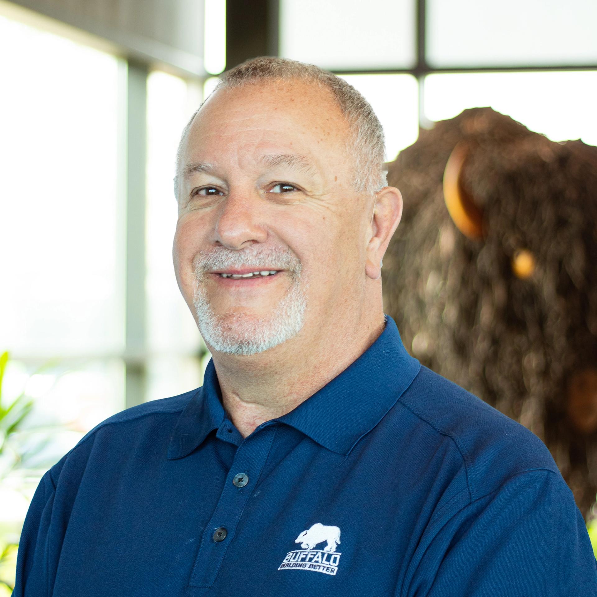John Hunter wearing a suit, looking distinguished in a bright, modern office.